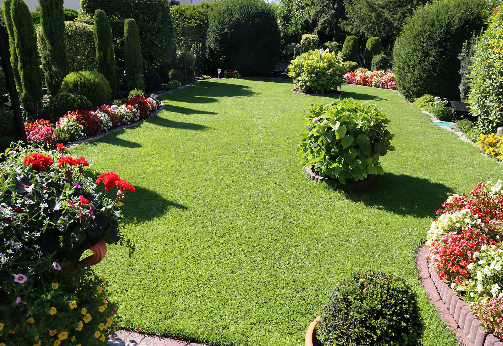 Gepflegter Garten mit Rasen, Hecken und Blumenbeeten